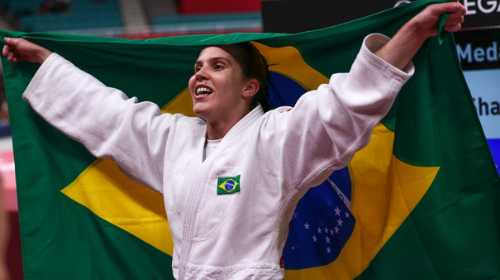 Alana Maldonado festeja o inédito ouro paralímpico do judô feminino com a bandeira do Brasil — Foto: Matsui Mikihito/CPB 2